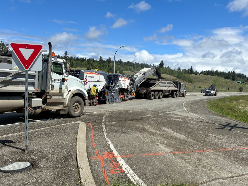 Milling machine removing asphalt on Highway 97 near Lac La Hache, with a Dawson Construction dump truck collecting the millings